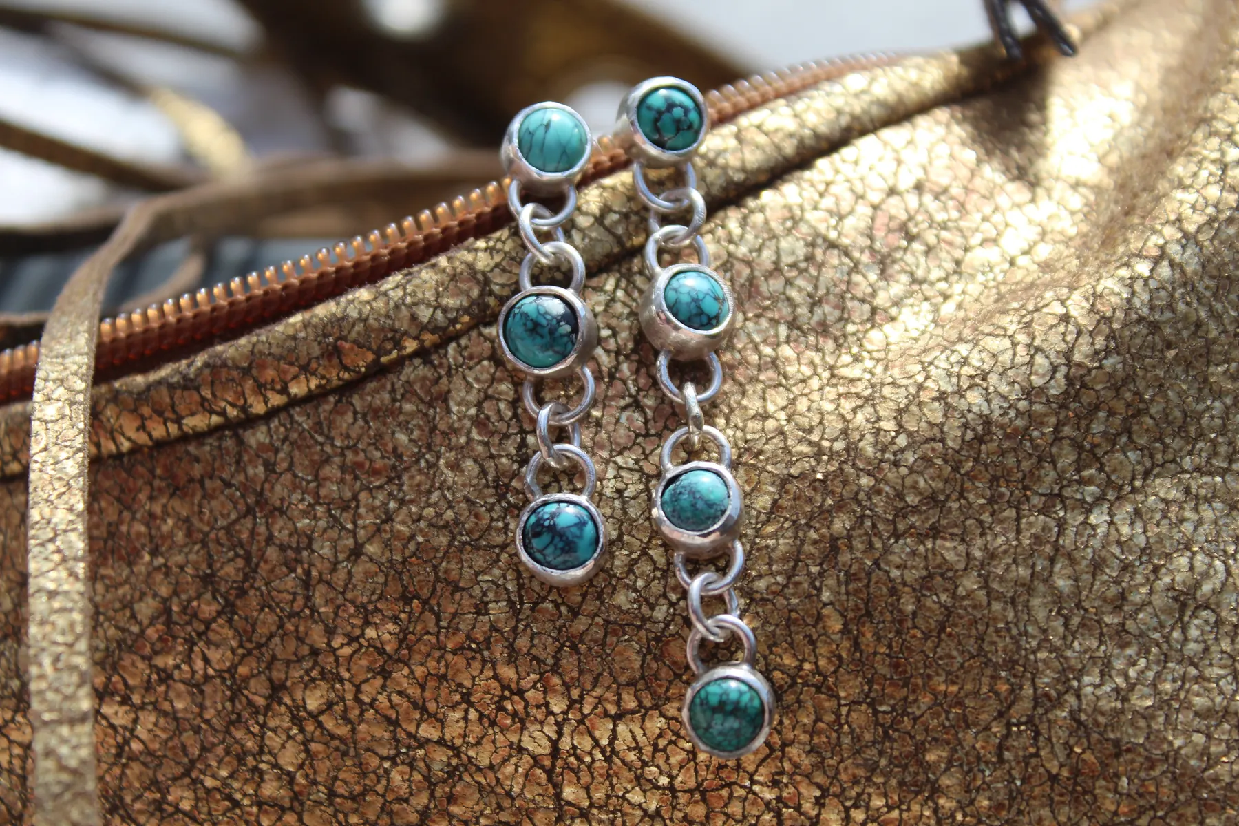 Robin-inspired silver jewelry arranged on a gold purse